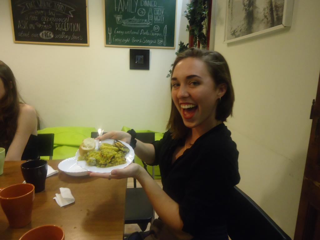 Gracia City Hostel バルセロナ エクステリア 写真 A woman holding a plate of food