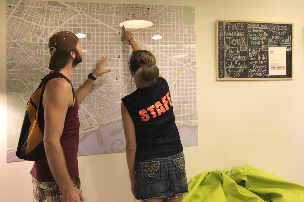 Gracia City Hostel バルセロナ エクステリア 写真 Hostel staff helping a guest with a map